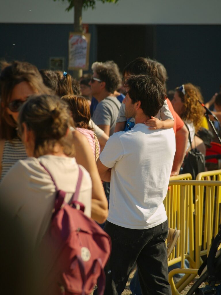 Attendees forming an organized serpentine queue using interlocking steel crowd barriers at a busy festival entrance